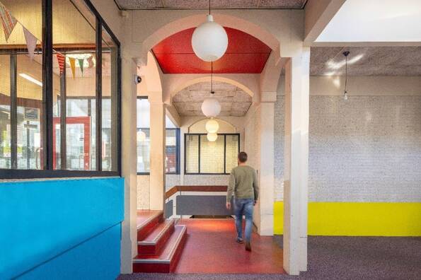 Foto van het interieur met betonnen bogen, trappen en pilaren.